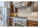 The kitchen features a stainless steel range and hood, tiled backsplash, and wood cabinetry at 20187 E Sonoqui Blvd, Queen Creek, AZ 85142