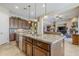 Open kitchen with granite countertops, island sink, stainless steel appliances, and a view of the living room at 20187 E Sonoqui Blvd, Queen Creek, AZ 85142