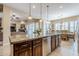 Kitchen island with granite countertops, stainless steel appliances, and a view into the dining and living areas at 20187 E Sonoqui Blvd, Queen Creek, AZ 85142