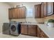 Well-equipped laundry room with modern washer and dryer, ample cabinet space, and a sink at 20187 E Sonoqui Blvd, Queen Creek, AZ 85142