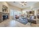 Bright living room featuring stone fireplace, large windows, and plush furniture at 20187 E Sonoqui Blvd, Queen Creek, AZ 85142