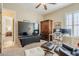 Spacious living room featuring a large TV, a ceiling fan, and modern, stylish furniture at 20187 E Sonoqui Blvd, Queen Creek, AZ 85142