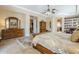 Bright bedroom featuring tile floor, tray ceiling, stylish furniture, and passageway to the main bathroom at 20187 E Sonoqui Blvd, Queen Creek, AZ 85142