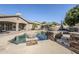 Backyard featuring a sparkling pool with stone features, complemented by the home's architecture at 20187 E Sonoqui Blvd, Queen Creek, AZ 85142