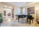 This sitting room features a grand piano, hardwood-style tile floors and bright windows at 20187 E Sonoqui Blvd, Queen Creek, AZ 85142