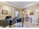 Bright sitting room with a grand piano and hardwood-style tiled floors at 20187 E Sonoqui Blvd, Queen Creek, AZ 85142