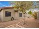 Backyard view with decorative rock features, block wall, desert landscaping, and outdoor patio area at 2021 S 84Th Ave, Tolleson, AZ 85353