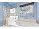 Bathroom featuring a soaking tub with a shower and a window with natural light at 2021 S 84Th Ave, Tolleson, AZ 85353