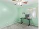 Bedroom with light green walls, a ceiling fan, and a black sit-stand desk with a computer at 2021 S 84Th Ave, Tolleson, AZ 85353