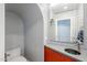 Stylish powder room featuring vibrant orange cabinets, and modern mirror fixture at 20704 N 90Th Pl # 1065, Scottsdale, AZ 85255