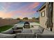 Cozy backyard patio with a fire pit and comfortable seating, adjacent to a refreshing pool and green lawn at 20954 E Camacho Ct, Queen Creek, AZ 85142