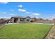 This expansive backyard features lush green grass, desert landscaping, and a covered patio area at 20954 E Camacho Ct, Queen Creek, AZ 85142