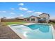 This backyard features a refreshing pool, lush green grass, desert landscaping, and a covered patio at 20954 E Camacho Ct, Queen Creek, AZ 85142