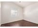 This light-filled bedroom has a window and beautiful, dark wood floors at 21629 N Dietz Dr, Maricopa, AZ 85138