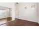 Bright bedroom featuring wood floors, sliding mirrored closet doors and neutral paint at 21629 N Dietz Dr, Maricopa, AZ 85138