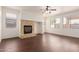 Cozy living room featuring wood floors, a fireplace, and ample natural light at 21629 N Dietz Dr, Maricopa, AZ 85138