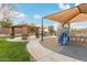 Community playground featuring covered play structures, sandy ground cover, and sidewalks in common area at 21629 N Dietz Dr, Maricopa, AZ 85138