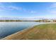 Community pond with blue water, shoreline grass and neighborhood homes in the background at 21629 N Dietz Dr, Maricopa, AZ 85138