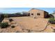 Wide backyard showcasing desert landscaping and a single chair on the outskirts of the yard at 21889 N 259Th Ave, Buckeye, AZ 85396