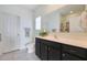 Well-lit bathroom with a vanity, framed mirror, and dark cabinets at 21889 N 259Th Ave, Buckeye, AZ 85396