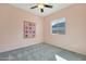 A cozy bedroom with pink walls, carpet flooring, and a window offering natural light at 21889 N 259Th Ave, Buckeye, AZ 85396