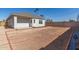 Wide angle of home's backyard with door, covered patio, fresh landscape, new fence, and palm trees towering above at 2227 W Cambridge Ave, Phoenix, AZ 85009