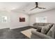 Comfortable living room featuring a cozy couch, natural light, and a modern ceiling fan at 2227 W Cambridge Ave, Phoenix, AZ 85009