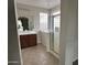 Bathroom with a glass-enclosed shower, double sink vanity, and natural light from the glass-block window at 2344 E Alida Trl, Casa Grande, AZ 85194