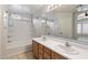 Bathroom featuring a double sink vanity, large mirror and shower-tub combination at 24118 W Desert Bloom St, Buckeye, AZ 85326