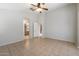 Spacious bedroom with tile flooring, ceiling fan, and ensuite bathroom entrance at 24118 W Desert Bloom St, Buckeye, AZ 85326