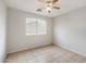 Bright bedroom with tile flooring, ceiling fan, and a window with blinds at 24118 W Desert Bloom St, Buckeye, AZ 85326