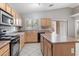 Kitchen with island, black appliances, tile floor, and convenient access to backyard at 24118 W Desert Bloom St, Buckeye, AZ 85326