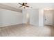 Spacious, tiled living room with neutral walls and ceiling fan at 24118 W Desert Bloom St, Buckeye, AZ 85326