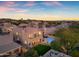 Home at dusk featuring backyard with a pool, lush landscaping, and desert landscaping at 2419 E Goldenrod St, Phoenix, AZ 85048