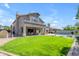 Expansive backyard with a lush green lawn, inviting pool, and covered patio at 2419 E Goldenrod St, Phoenix, AZ 85048