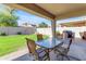 Covered patio with outdoor dining set overlooking the grassy backyard and BBQ area at 2419 E Goldenrod St, Phoenix, AZ 85048