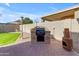 Outdoor BBQ area featuring a built-in grill on a brick patio with a cozy chiminea at 2419 E Goldenrod St, Phoenix, AZ 85048