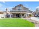 Beautiful backyard featuring a lush lawn, covered patio, built in grill, and a sparkling pool at 2419 E Goldenrod St, Phoenix, AZ 85048