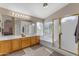 Bright bathroom featuring a large vanity, soaking tub, and separate shower, with large window and neutral tones at 2419 E Goldenrod St, Phoenix, AZ 85048