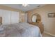 Bedroom with neutral colored walls, double door closet, and full dresser with round mirror at 2419 E Goldenrod St, Phoenix, AZ 85048