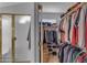 Walk-in closet with a separate closet with a gold-trimmed glass door in the background at 2419 E Goldenrod St, Phoenix, AZ 85048