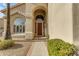 Welcoming front entrance with a wooden door, arched windows, and manicured greenery at 2419 E Goldenrod St, Phoenix, AZ 85048