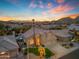 Home at dusk featuring a well-maintained lawn, desert landscaping, and a three car garage at 2419 E Goldenrod St, Phoenix, AZ 85048