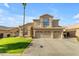 Charming home featuring a lush green lawn, a three-car garage, and elegant architectural details at 2419 E Goldenrod St, Phoenix, AZ 85048