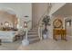 Grand foyer with a curved staircase, elegant decor, and tiled flooring leading to a spacious living area at 2419 E Goldenrod St, Phoenix, AZ 85048