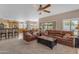 Spacious living room with leather furniture, ceiling fan, and sliding glass doors to the backyard at 2419 E Goldenrod St, Phoenix, AZ 85048