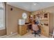 A cozy office space with a built-in desk and shelving and a unique round window at 2419 E Goldenrod St, Phoenix, AZ 85048