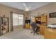 Office with large desk, ceiling fan, and natural light from the window for a comfortable workspace at 2419 E Goldenrod St, Phoenix, AZ 85048