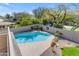 A well-maintained pool with clear blue water, surrounded by a patio and lush landscaping at 2419 E Goldenrod St, Phoenix, AZ 85048