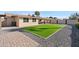 Well-maintained backyard featuring artificial turf, gravel, and a covered patio at 2525 E Nisbet Rd, Phoenix, AZ 85032